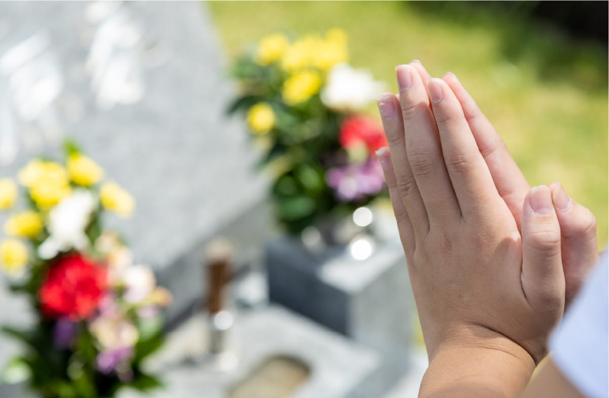 お墓に手を合わせる様子