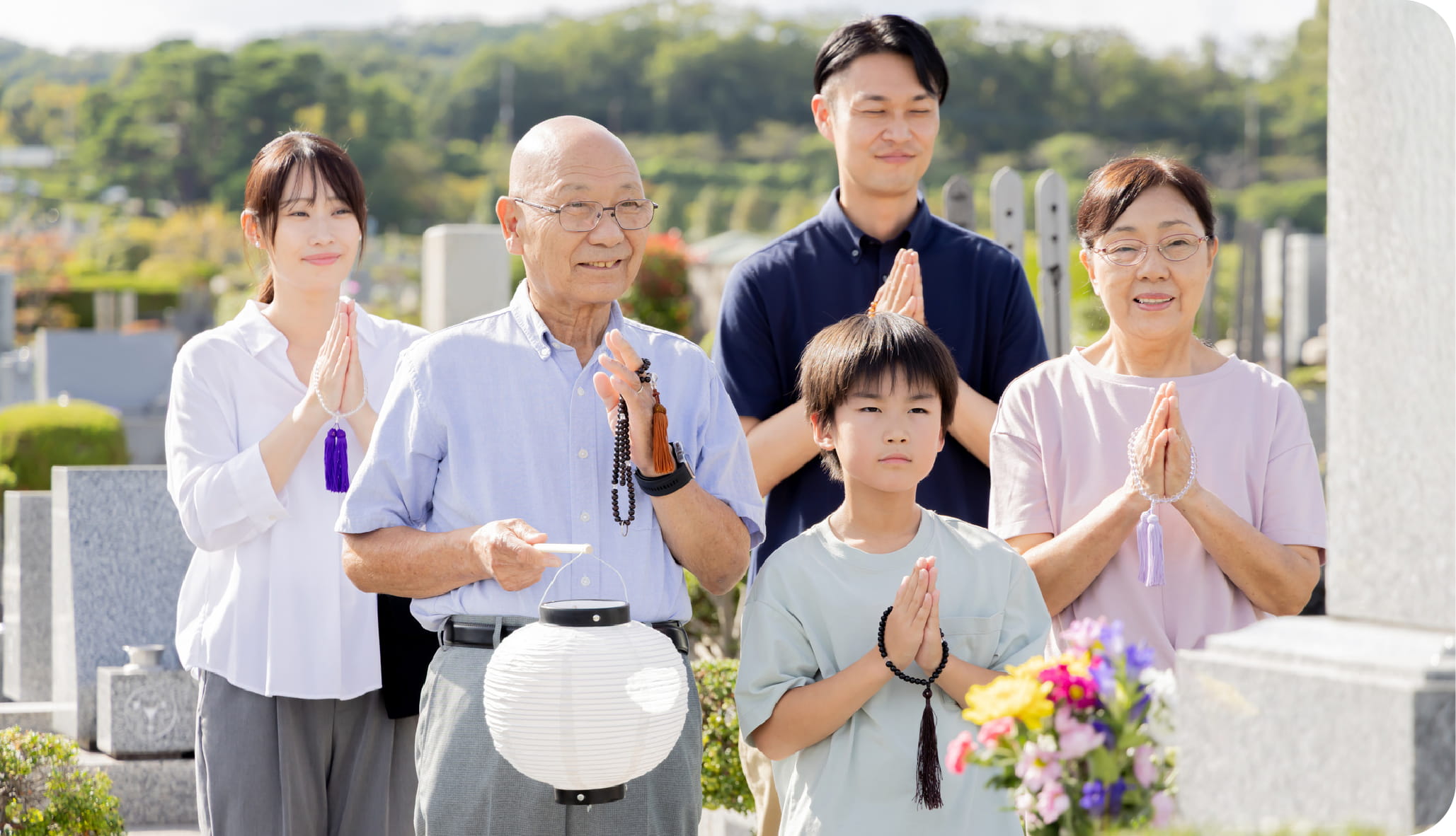 お墓に手を合わせる家族